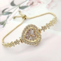 Detail view of gold heart watch with adjustable slide buckle and floral diamond accents - Gold Case White Dial