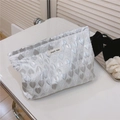 Detailansicht der silbernen Kosmetiktasche mit Herzsteppung und glänzender Oberfläche - Silber