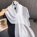 Detailed view of the sheer white chiffon scarf texture with elegant camellia floral accent - White