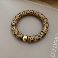 Detailansicht von Leopard-Röhrenperlen mit vergoldetem Trennelement an einem Armband - Armband-Braun