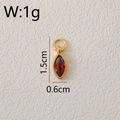 Dettaglio macro del ciondolo marquise rosso da 1,5 cm con montatura dorata e anello - Gennaio-Rosso
