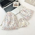 Three sizes of seersucker drawstring bags with cute puppy prints on a desk - Latte Blue Dog