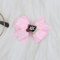 Detail of pink polka dot hair bow clip featuring ABC blackboard and pencil ornament - Light Pink