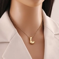 Dettaglio ravvicinato della collana con pendente lettera L placcata oro 18K su modella - Lettera L