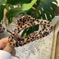 Leopard print hair claw clip in resin finish for thick hair shown in a hand-held view - Oval Hollow Leopard Hair Claw