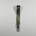 Macro detail of military green nylon wristlet keychain with metal D-ring on white surface - Army Green