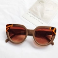 Retro cat eye sunglasses with tortoise shell frame and dark brown lenses on white fabric - Khaki