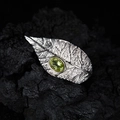 Silver leaf necklace set featuring a polished oval green peridot stone on dark rock - Ring / Silver / Peridot