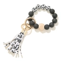 Detail of beaded keychain with matte silicone beads, wooden bead and cow print leather tassel - Black Cow Pattern