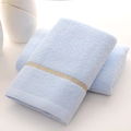 Plush light blue cotton towel with yellow stripe detail on a clean white background - Simple Blue