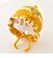 Detail view of cute yellow knitted baby bonnet with 3D flower and ruffled edges. - 3M-2Y / Yellow