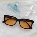 Cat eye sunglasses in black frame with orange lenses on white textured background - Black Orange