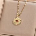 Close-up of golden evil eye coin pendant with colorful zircon stones on jewelry box - Gold Color Multicolored Zirconia