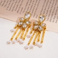 Detalle de pendientes de flores doradas con cristales y borlas largas de perlas blancas - Dorado