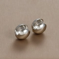 Detail van minimalistische zilveren bolvormige oorbellen met gepolijste spiegelafwerking - Zilver