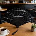 Traditional black folding fan with bamboo leaf patterns and elegant black tassel - Style 34 (Bamboo Reporting Peace) (New Style)