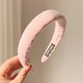 Close-up of a pink pleated suede headband featuring a black handmade label on inner side - Girl Pink