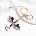 Detailed close-up of golden dragon keychain with purple enamel finish and sturdy ring - Gray