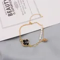 Gold plated double chain bracelet with black clover, pearls and pinecone charm - Black Clover Double Layer Bracelet