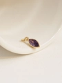 Macro shot of marquise-cut purple birthstone pendant with 18K gold plated bezel setting - February/Purple