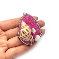 Pendente in resina rosa con conchiglie naturali e strass bianchi, mostrato sulla mano - Rosa