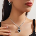 Close-up of sparkling heart-shaped black gemstone necklace and earrings set on model - Black 206-Large Heart Full Rhinestone