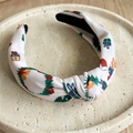 Close-up of pink Christmas headband with festive gift boxes and floral patterns - Holiday Gift Print / White