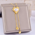 Elegant gold heart pendant necklace with pearl inlay and delicate tassels on a display box - Heart