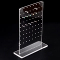 Makro-Detail von dickem Acryl-Ohrringständer mit Steckern auf schwarzem Hintergrund - Rechtwinkliger Stil