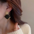 Modern geometric square drop earrings in gold and black metal with woven texture on model - Black & Gold