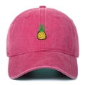 Close-up of yellow pineapple embroidery on a distressed rose red washed cotton baseball cap - Rose Red
