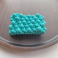 Close-up of mint green multilayer resin pearl beaded stretch bracelet on a wooden tray - Indigo Blue