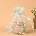 Light green organza drawstring bag with white flowers and gold glitter patterns - Light Green