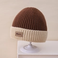Dettaglio del berretto in maglia bicolore con righe verticali e targhetta in pelle marrone - Solo Cappello / caffè