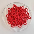 Elastic red knitted hair ties with ribbed texture neatly stacked on glass tray - Red 100Pcs OPP Bag