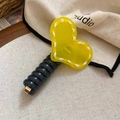 Detail of yellow acrylic heart hair tie with white stitching and textured black band - Yellow