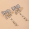 Detalle de pendientes de lazo plateados con pedrería pavé y borlas de cristal - Plateado