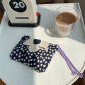 Borsa blu scuro a pois con stampa floreale bianca e coulisse viola su scrivania bianca - Grande Fiore Nero
