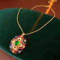 Macro view of vintage gold-plated necklace with colorful enamel and green gemstone pendant - Vintage Enamel Green Gemstone Pendant Necklace