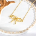 Primer plano del colgante de lazo bañado en oro 18k con textura de caviar y circón - Lazo de Cuentas Dorado