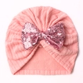 Pink knit baby beanie featuring a large sparkling sequin bow on a soft white background - Snow Bud