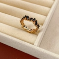 Detail eines Goldrings mit abwechselnd schwarzen quadratischen Steinen und Zirkonia - Gold Schwarz
