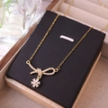 Elegante collana dorata con ciondolo a fiocco e margherita e pavé di zirconi cubici - Oro