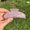 Pink and blue marble texture acetate hair claw clip for women held in hand - Marshmallow