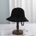 Classic black woven bucket hat with adjustable chin strap displayed on a wooden stand - M (56-58cm) / Black