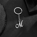 Polished stainless steel keychain featuring a cursive letter M charm in silver finish - M