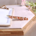 Golden hair clip featuring raw orange natural crystals on a minimalist metal base - Orange Moonstone + Gold Clip