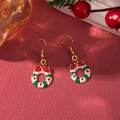 Detailed close-up of Christmas wreath earrings with red bows on festive red background - D1297 (Bowknot Wreath)