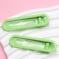 Pair of 6cm lime green U-shaped glossy metal hair clips on a pink and white background - Matcha Green