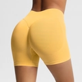 Detail of seamless scrunch butt lifting shorts in yellow for high-waisted yoga fitness - Yellow